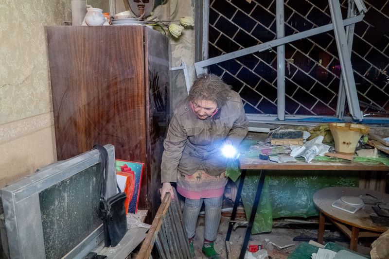Ukraine, Charkiw: Eine Frau betrachtet nach einem russischen Luftangriff am zweiten Weihnachtsfeiertag die Zerstörungen in einem Zimmer.
