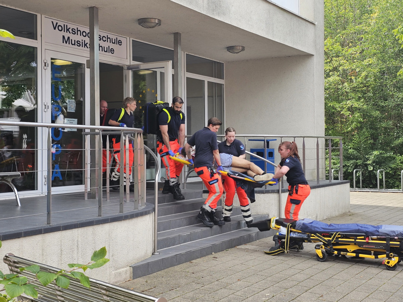 Der angegriffene Lehrer wird mit lebensbedrohlichen Verletzungen in den Rettungswagen gebracht.