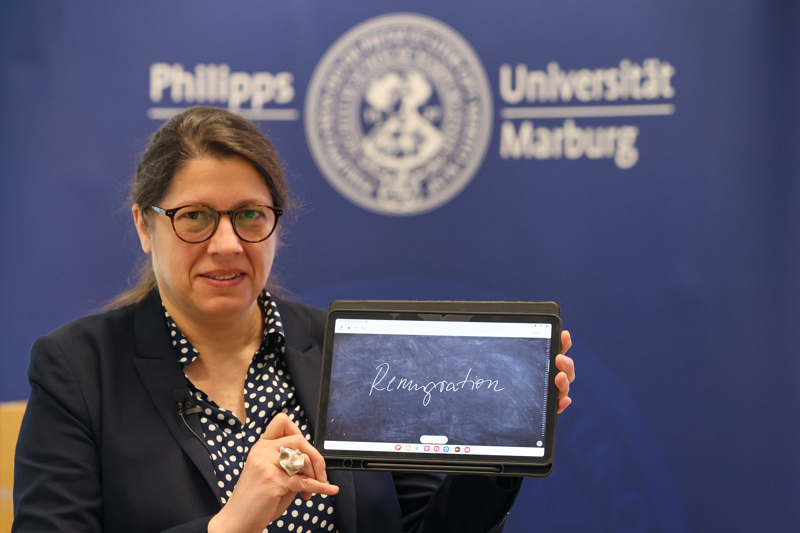 Constanze Spieß, Sprachwissenschaftlerin an der Philipps-Universität Marburg und Jury-Sprecherin, präsentiert den Begriff „Remigration“ auf einem Tablet.