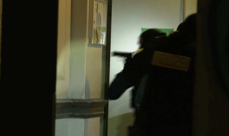 Mit gezogener Waffe stürmt die Polizei eine Wohnung eines „Zora“-Mitglieds.