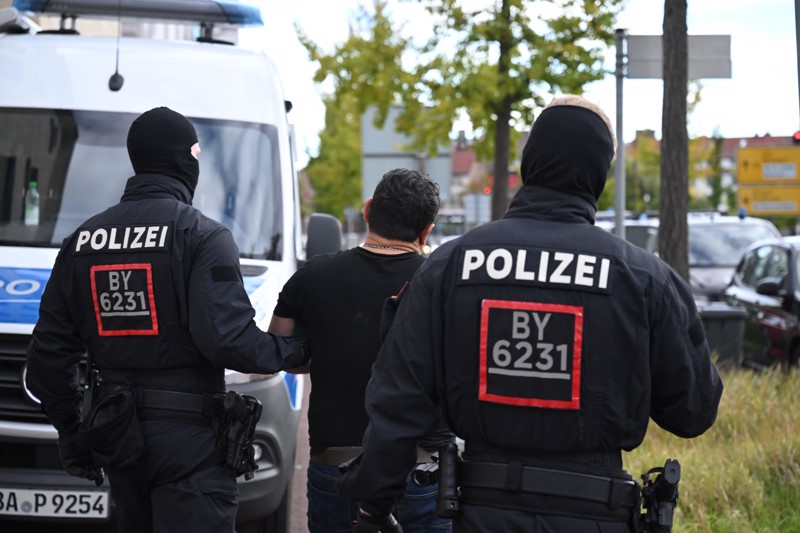 Polizisten führen einen Tatverdächtigen ab. (Symbolfoto)