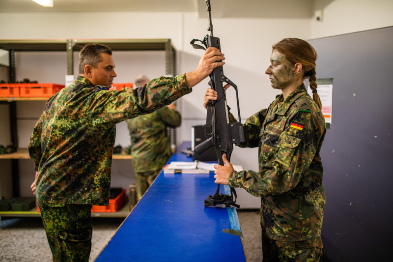  Alltag in der Kaserne: Eine Reservistin erhält in der Waffenkammer ein Sturmgewehr vom Typ G36. 