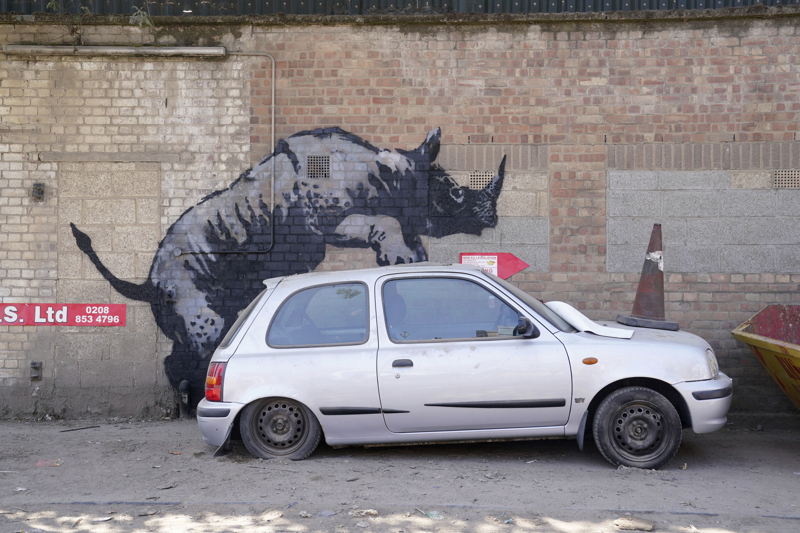 Viele seiner Graffitis haben durchaus Witz: Im August 2024 wurde in London dieses Schrottauto-bezwingende Nashorn entdeckt.