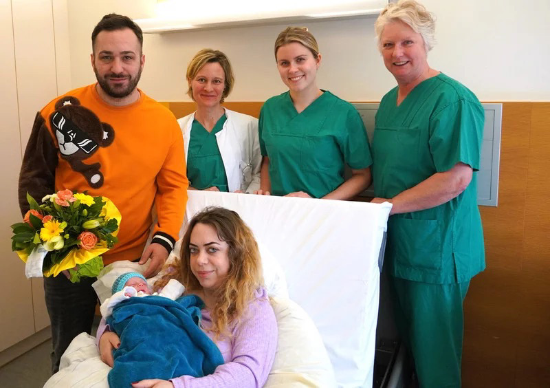 Hebamme Andrea Marschall, Ärztin in Weiterbildung Dr. med. Carly Grant und Oberärztin Dr. med. Jennifer Dupont der Klinik für Gynäkologie (v.r.n.l.) freuen sich stellvertretend für das gesamte Team mit den frisch gebackenen Eltern: Papa Zenel und Mama Mjaftime.