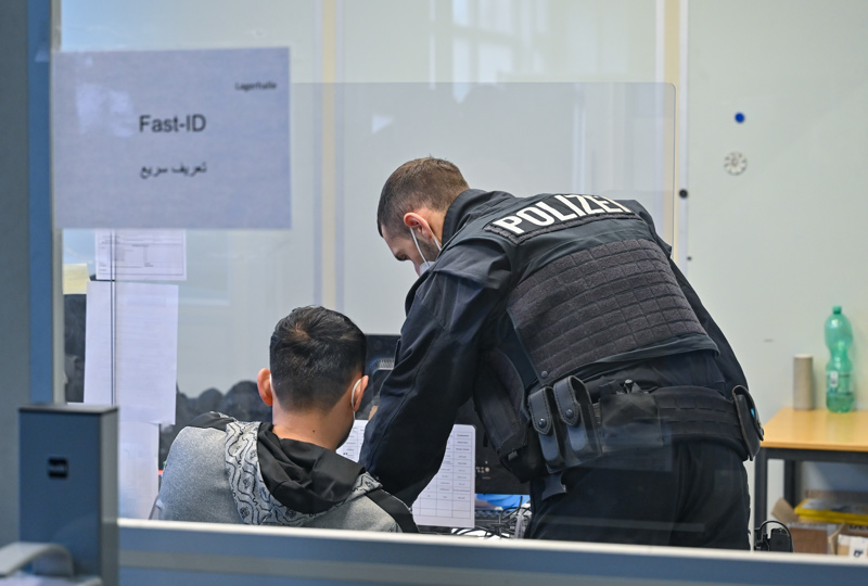 Ein Beamter der Bundespolizei nimmt die Daten eines Migranten auf.