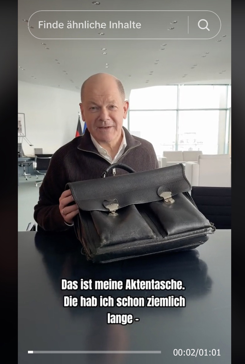 Olaf Scholz überrascht mit Akten in seiner Aktentasche