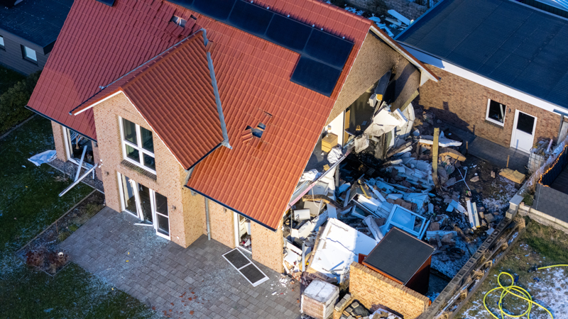 Aus der Vogelperspektive: Die Terrassentüren sind verformt und Schutt und zerstörte Möbel liegen auf der offenen Gebäudeseite.